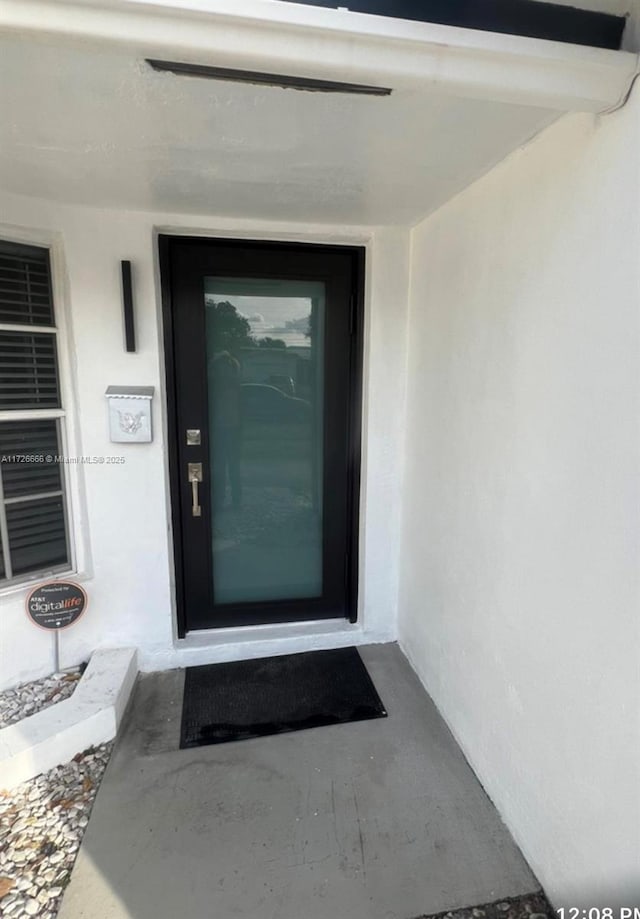 entrance to property with stucco siding