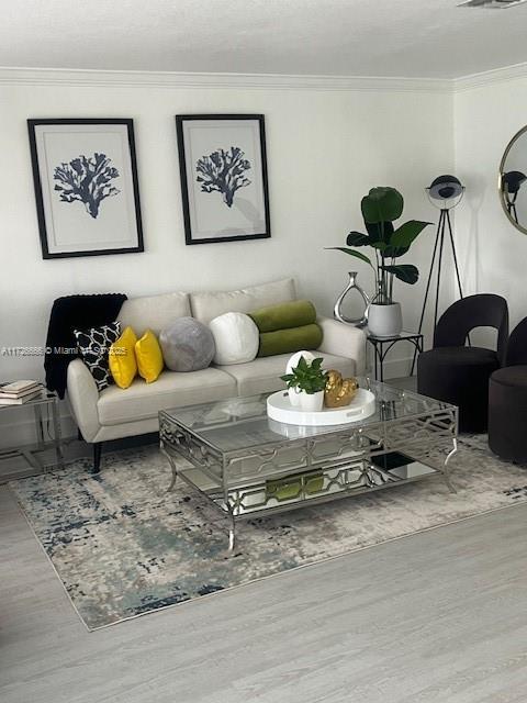 living room with hardwood / wood-style floors and ornamental molding