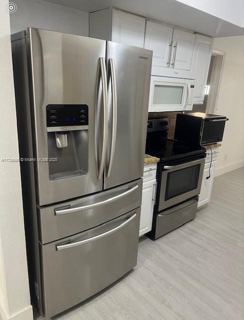 kitchen featuring white cabinetry, appliances with stainless steel finishes, and light hardwood / wood-style floors