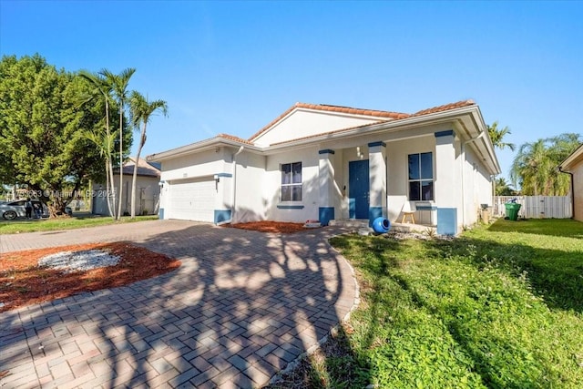 mediterranean / spanish home featuring a garage and a front yard