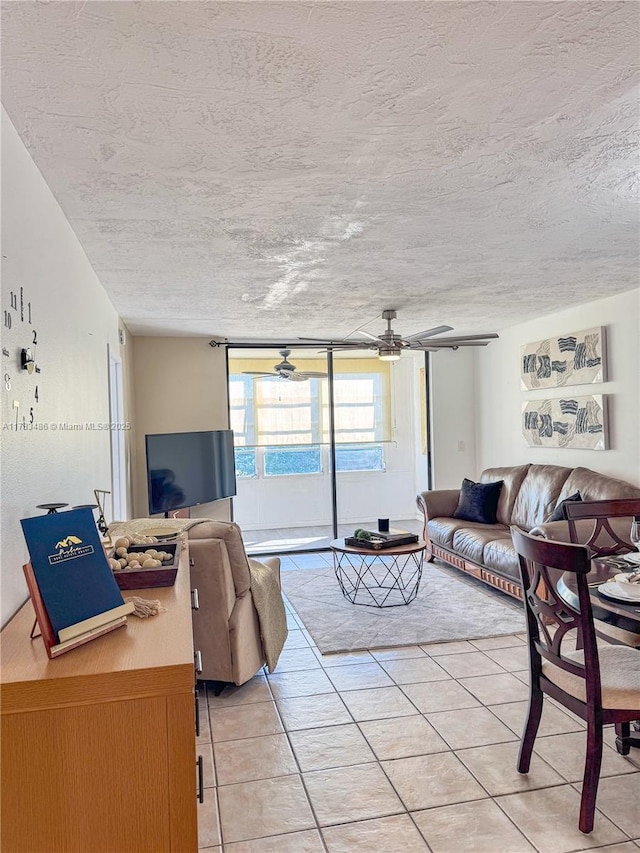 living area featuring light tile patterned floors, a textured ceiling, and a ceiling fan