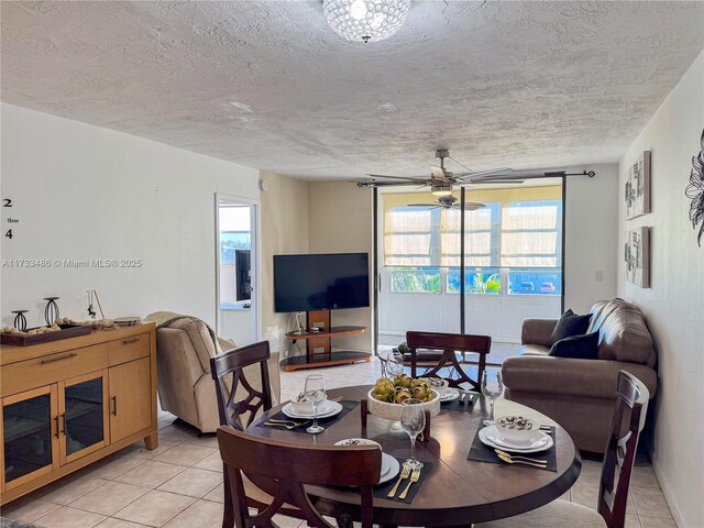 tiled dining area with ceiling fan and a textured ceiling