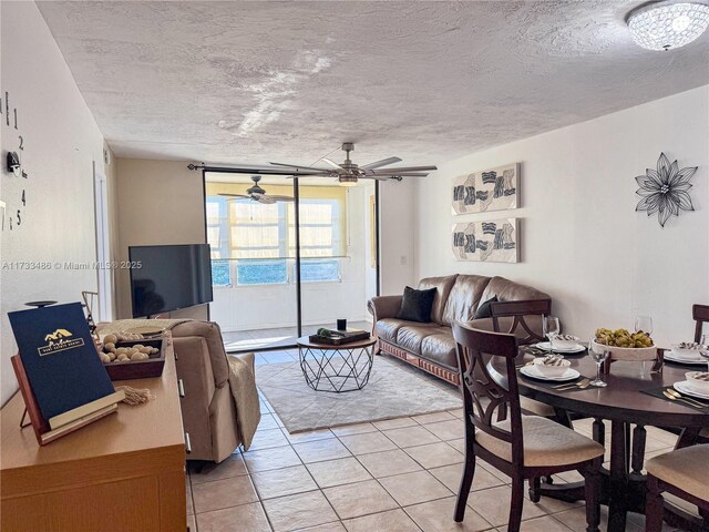 living room with light tile patterned flooring, ceiling fan, and a textured ceiling