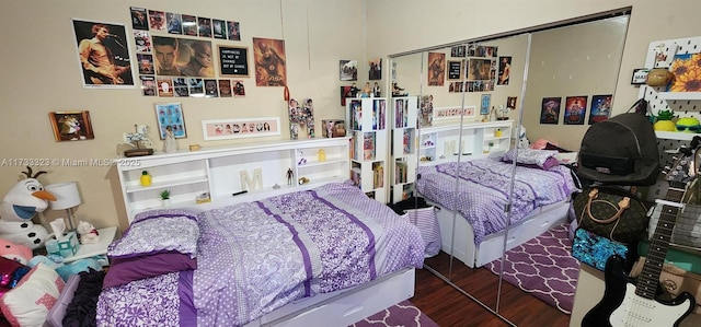 bedroom with dark hardwood / wood-style flooring and a closet