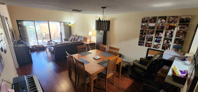 dining space featuring a textured ceiling and dark hardwood / wood-style flooring