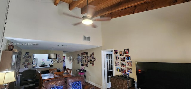 living room featuring beamed ceiling, ceiling fan, and wood ceiling