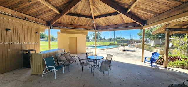 view of patio featuring a swimming pool with hot tub and a gazebo