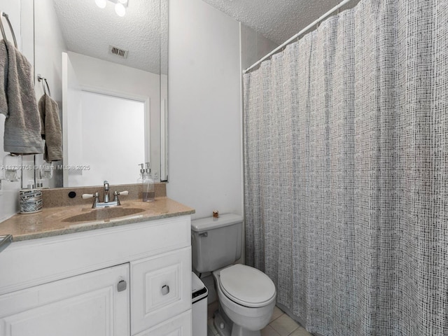 bathroom featuring tile patterned flooring, vanity, a textured ceiling, and toilet