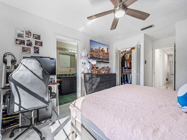 bedroom featuring connected bathroom, a textured ceiling, ceiling fan, and a closet