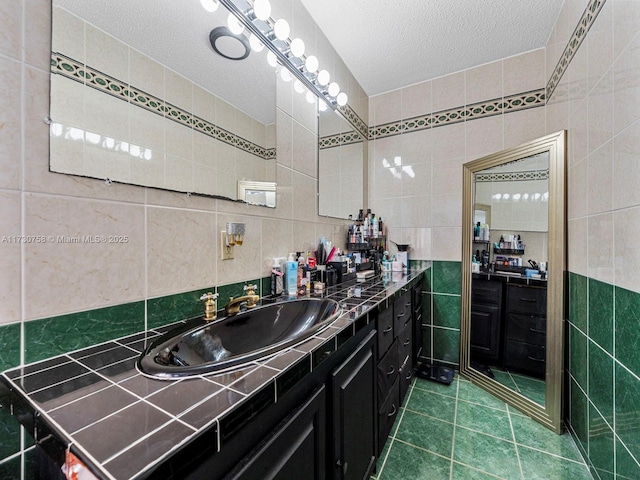 bathroom with vanity, tile walls, tile patterned floors, and a textured ceiling