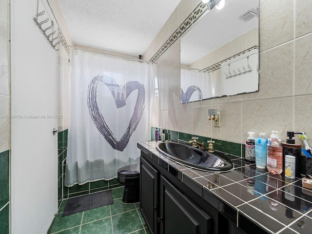 full bathroom with toilet, a textured ceiling, tile walls, vanity, and shower / bathtub combination with curtain