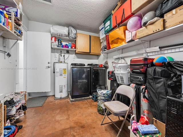 laundry room featuring cabinets, electric water heater, washing machine and clothes dryer, and a textured ceiling