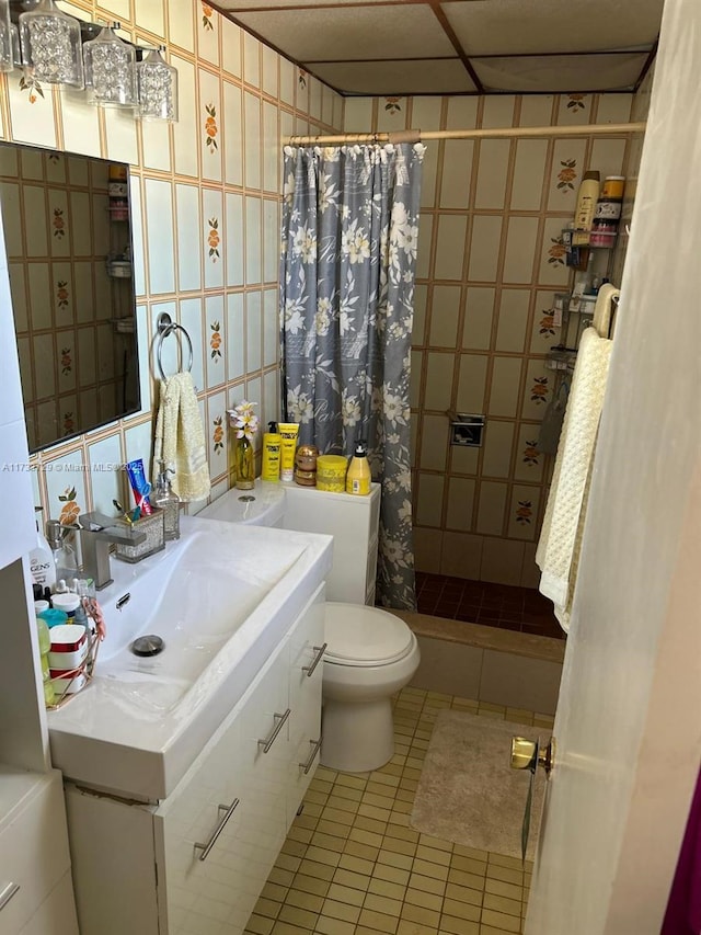 bathroom featuring sink, tile walls, tile patterned flooring, a shower with shower curtain, and toilet