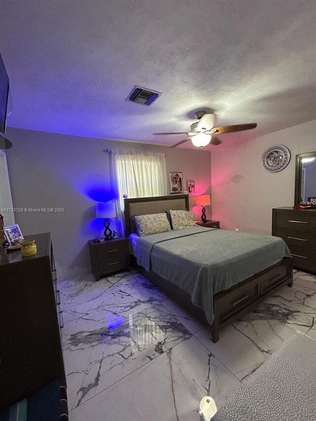 bedroom featuring ceiling fan and a textured ceiling