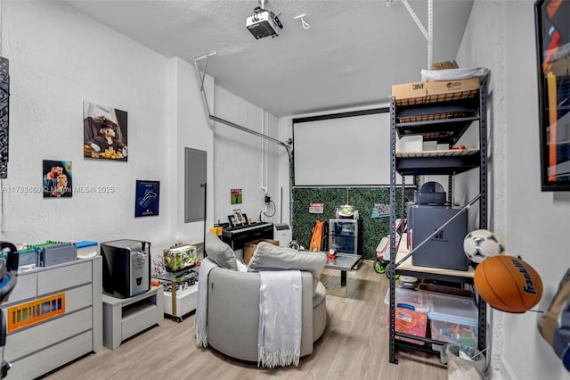 interior space featuring a textured ceiling, electric panel, and light hardwood / wood-style floors