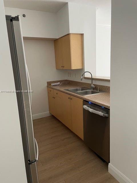 kitchen featuring light brown cabinetry, sink, light hardwood / wood-style floors, and appliances with stainless steel finishes