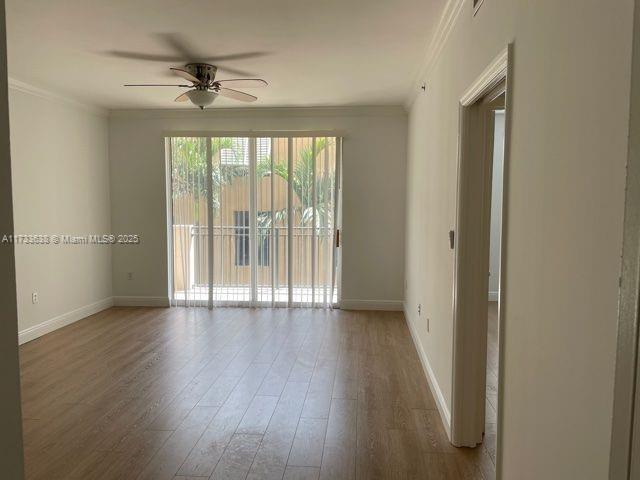 spare room with hardwood / wood-style flooring, ornamental molding, and ceiling fan