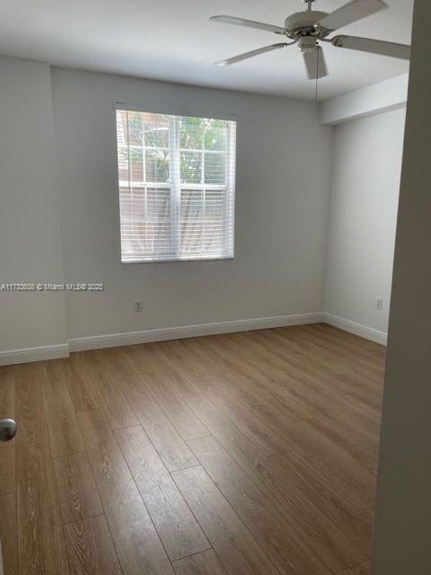 unfurnished room with wood-type flooring and ceiling fan