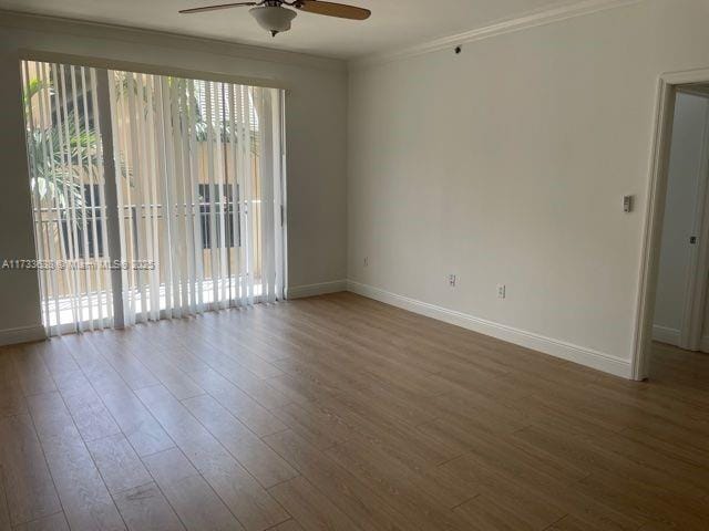 unfurnished room featuring wood-type flooring, crown molding, and ceiling fan