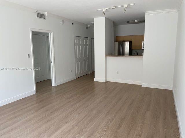 unfurnished room with hardwood / wood-style floors and crown molding