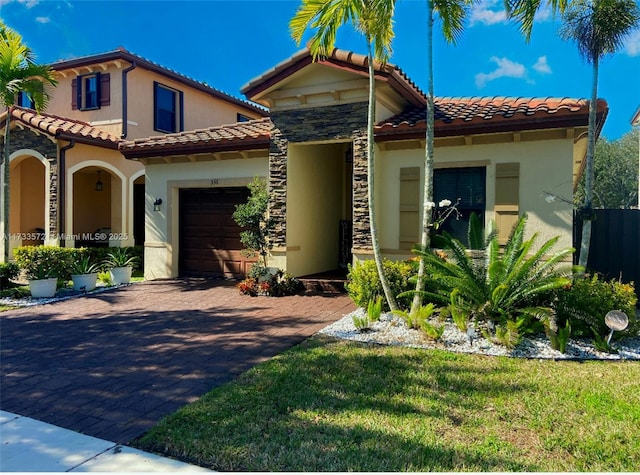 mediterranean / spanish home with a garage and a front yard