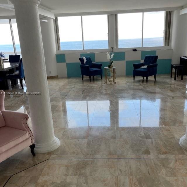 interior space featuring a water view and decorative columns