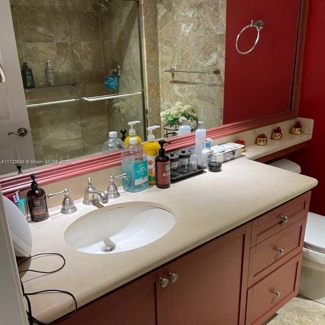 bathroom with toilet, vanity, and walk in shower