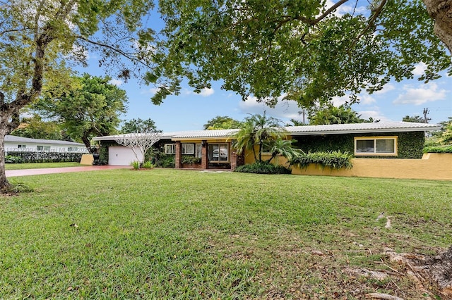 ranch-style house featuring a garage and a front lawn