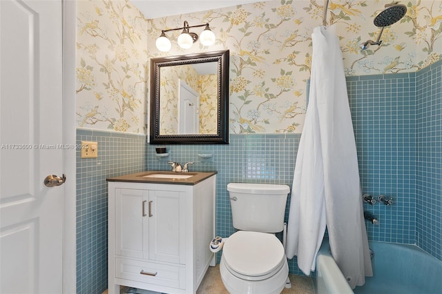 full bathroom with tile walls, vanity, toilet, and shower / bath combo