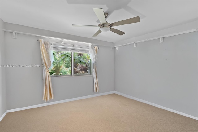 carpeted spare room featuring ceiling fan