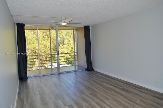 spare room featuring expansive windows, ceiling fan, hardwood / wood-style floors, and a textured ceiling