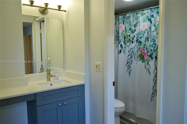 bathroom featuring vanity, walk in shower, and toilet