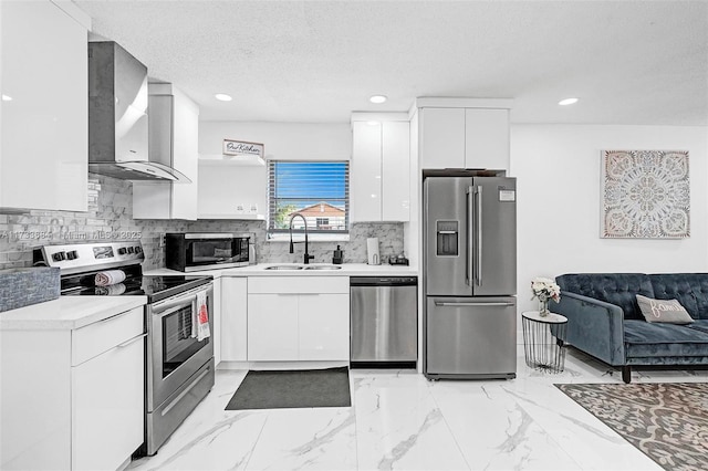 kitchen with sink, white cabinets, wall chimney exhaust hood, and appliances with stainless steel finishes