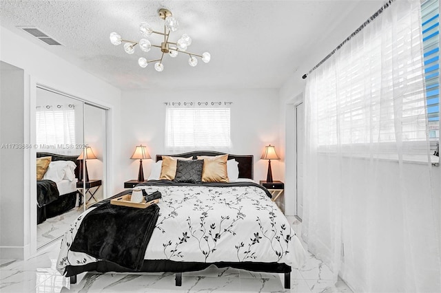 bedroom featuring an inviting chandelier and a textured ceiling