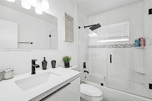 full bathroom featuring toilet, vanity, and shower / bath combination with glass door