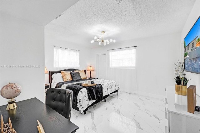 bedroom featuring a notable chandelier and a textured ceiling