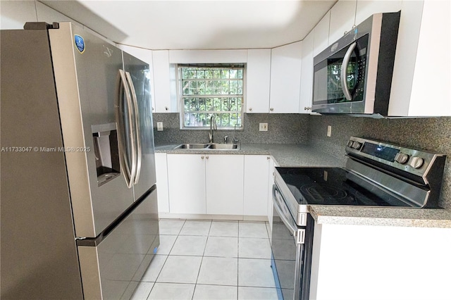 kitchen featuring appliances with stainless steel finishes, sink, white cabinets, and backsplash