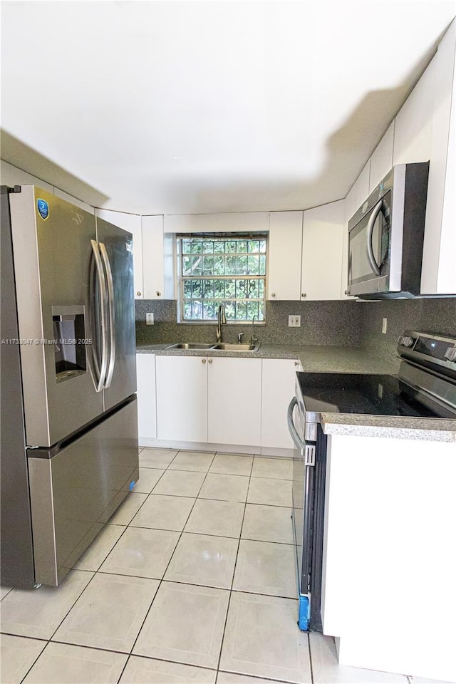 kitchen with white cabinetry, sink, light tile patterned flooring, and appliances with stainless steel finishes