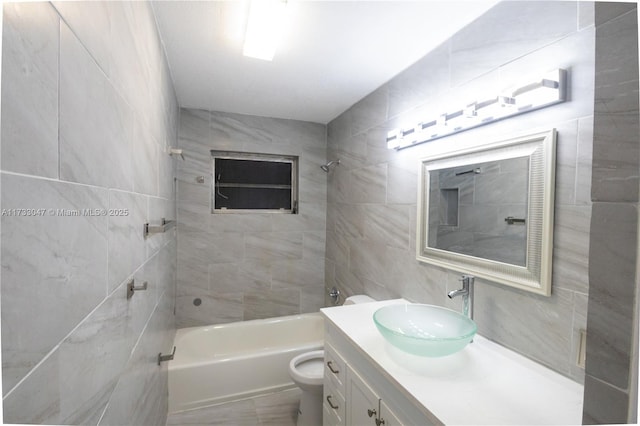 full bathroom featuring tiled shower / bath, vanity, and toilet