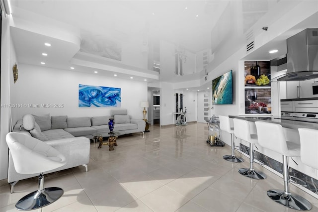 tiled living room featuring a high ceiling