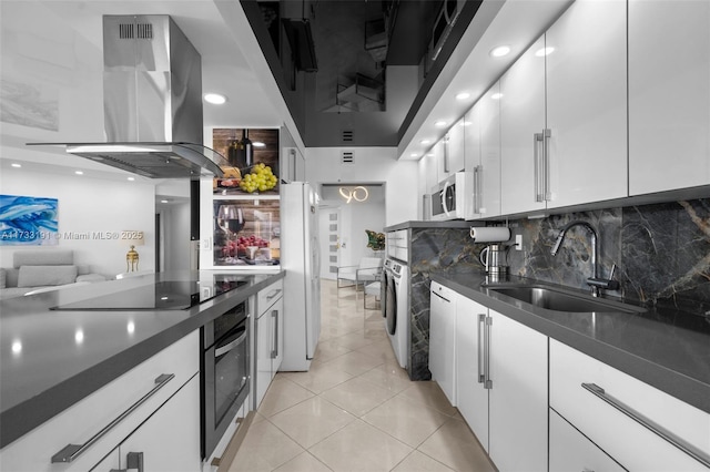 kitchen with sink, light tile patterned floors, appliances with stainless steel finishes, white cabinetry, and island range hood