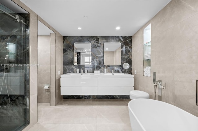 19667 Turnberry Way Unit 20B, Aventura, FL 33180 - bathroom with tile walls, a shower stall, double vanity, a freestanding tub, and recessed lighting