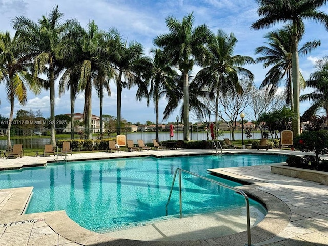 view of swimming pool featuring a patio and a water view