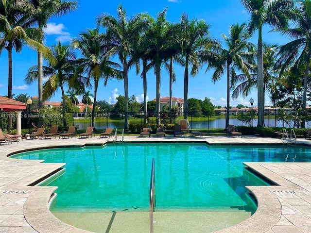 view of pool with a water view and a patio