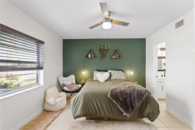 bedroom featuring visible vents, ensuite bath, baseboards, and light tile patterned floors