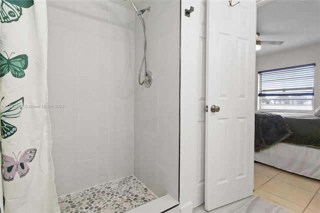 ensuite bathroom with tile patterned flooring, connected bathroom, and a tile shower