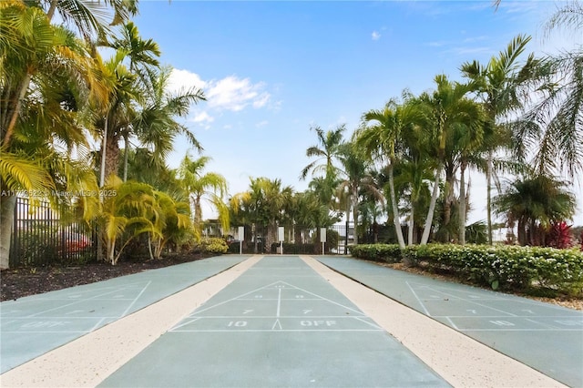 view of home's community with shuffleboard and fence