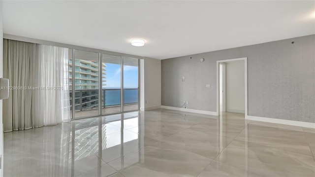 empty room featuring a wall of windows and a water view