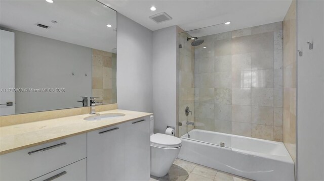 full bathroom with tiled shower / bath combo, vanity, tile patterned floors, and toilet