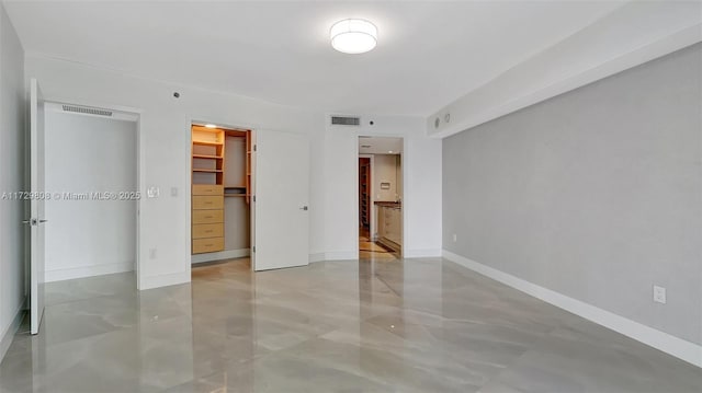 unfurnished bedroom featuring a walk in closet and a closet